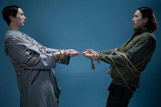 A man and a woman pulling in opposite directions on a rope.