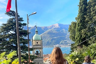 A woman’s brunette hair shines in the sun looking out at Lake Como, Italy.