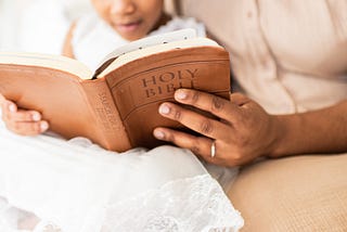 Mother and daughter reading the bible.