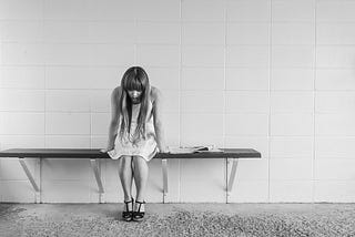 Unhappy girl sitting on a bench