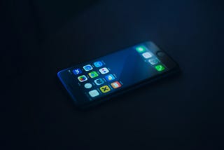 Black background, black phone with screen showing 16 icons