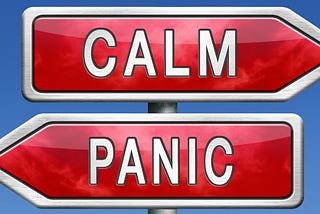 Two ‘red road signs’ on a blue background. With white lettering, the sign pointing to the right says “CALM.” The sign pointing to the left says “PANIC.”