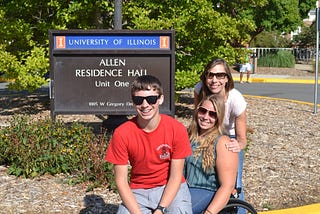 The author and her children Arielle and Kai in front of a sign for Allen Residence Hall.