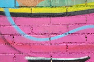 brick wall painted with abstract wavy lines and bright colors, mostly bright pink