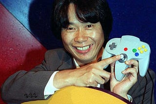 Miyamoto showing the analog stick of the N-64 controller.