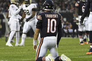 Bears quarterback Mitch Trubisky stares toward celebrating opponents from his knees on Sunday at Soldier Field.