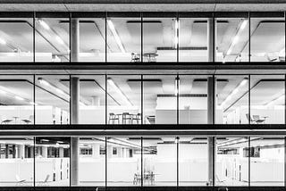 Black and White image of an unoccupied modern office space at night.