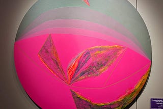 Circle artwork with graduated lines and a patch of vibrant pink color