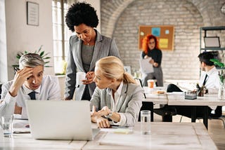 Three overwhelmed office workers looking at computer