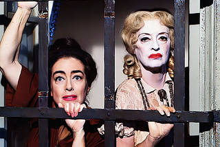 An anguished looking Joan Crawford and a heavily made up Bette Davis peering through black bars.