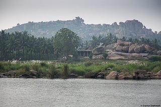 Hampi town by the Tungabhadra River. The river passes through the town and creates a serene atmosphere.