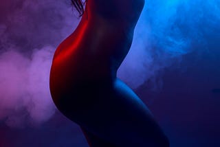Beautiful voluptuous naked female body wrapped in smoke