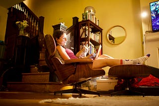 New Writers, How You Can Use Your Evenings To Build Your Dream Writing Business. Women sitting on her chair with a cat on her chest.