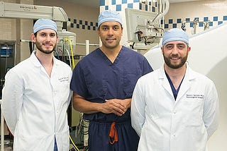 UPMC neurosurgeon David Okonkwo, center, with his current residents Gregory Weiner (left) and David Salvetti