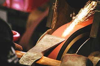 Stock photo of a man forging an axe.