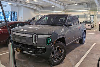 Rivian R1T charging inside of EA’s latest charging concept, a coverted auto garage with many chargers and lougnes