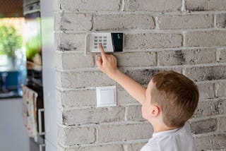 A kid setting an alarm for home entrance