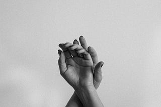 Hands elegantly crossed in the air, black and white.
