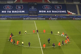 Photo by Xaiver Laine, AP Istanbul Basaksehir and PSG players kneel on the pitch against racism before the match.