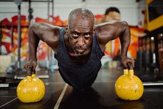 A black man in his fifty doing a workout in a fitness studio