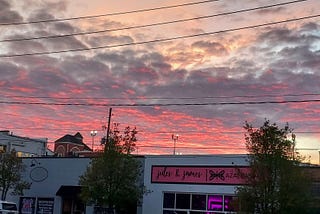 pink clouds over downtown building roofs