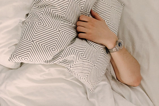 Person Holding Gray and White Throw Pillow