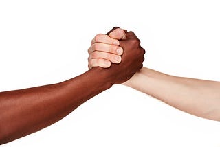 Fundo branco onde se vê uma pessoa negra e uma branca dando as mãos