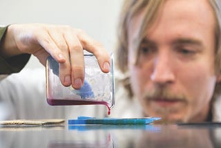A researcher pours fluid into a tray.