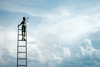 boy standing on a ladder in the clouds