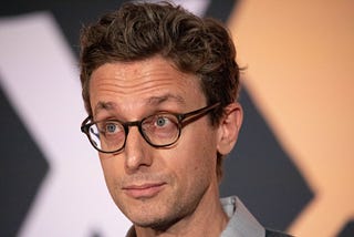 Close of Jonah Peretti — white man, with a thin face, thick-rimmed glasses and short hair —, founder of BuzzFeed.