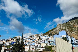 Houses are shown built together on the side of a mountain and painted in color blue