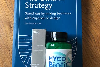 A book “the Umami Strategy” accompanied by a bottle of probiotics and probiotic-based facial cream from the company Nature Science and Bak.