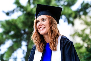 Woman wearing academic gown and graduate hat.
