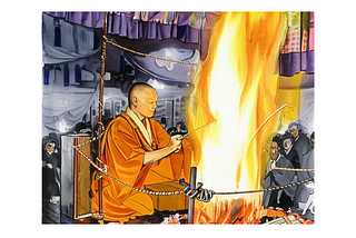 A Buddhist monk in an orange robe performs a traditional Goma fire ritual, seated close to a towering flame inside a temple, as onlookers watch with reverence behind a rope barrier.