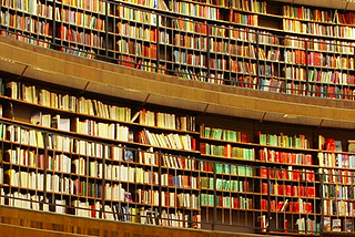 Estante com muitos livros e um senhor observando. Imagem para representar a quantidade enorme de informações que temos.