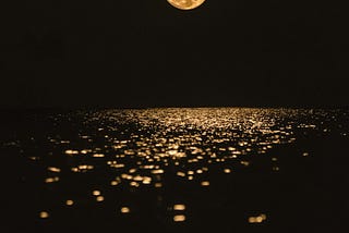 The moon shining over water.