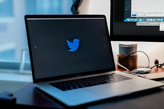 A Macbook displaying the Twitter logo in a browser.