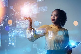 In this image, a woman interacts with a futuristic holographic interface, floating touchscreens alive with data charts and network connections. She gazes confidently at the digital expanse, her hand poised as if to manipulate the complex web of information, illustrating the seamless blend of technology and human interaction.