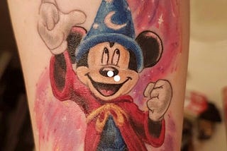 Micky Mouse pointing upwards while wearing wizard hat from the film Fantasia.