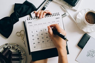 person writing on a calendar