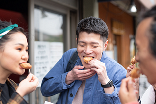 three people eating street food