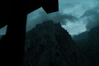 moody photo of mountains with clouds and a dark shadow of a house awning