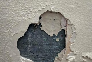 Paint chipping off the wall due to structural damping.