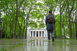 John Polonis walking into Grant’s Tomb in the rain and under green leaves