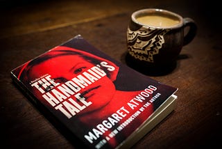 The Handmaid’s Tale book with a cup of coffee