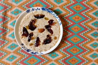 Broken wheat cooked in milk mainly with jaggery and topped with soaked nuts and dates