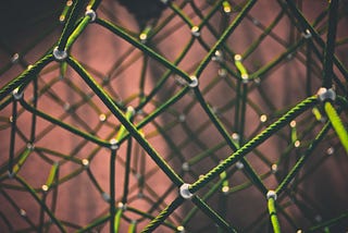 Green connected ropes forming a network with beads at each intersection.