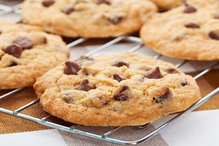 Close up shot of chocolate chip cookies sitting on a cooling rack