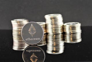 Ethereum coin standing in front of coin stacks