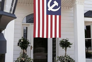 An American flag hanging outside a front door with Soviet hammer and sickle replacing the stars